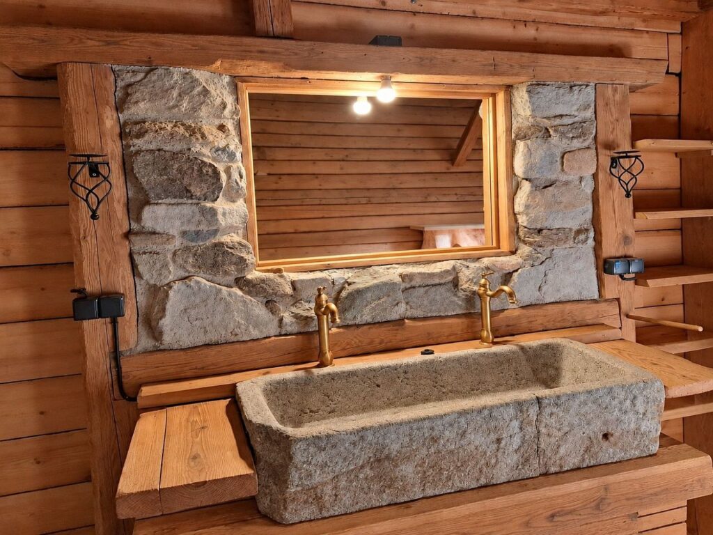 Granitwaschbecken mit viel Holz im Badezimer der Hütte